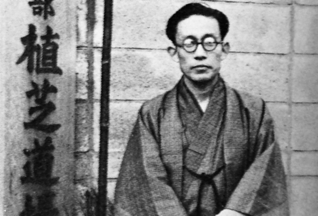 Then dojo-cho Kisshomaru Ueshiba standing in front of the entrance to the old Aikikai c. 1955